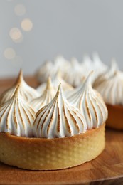 Photo of Tasty dessert. Tartlets with meringue on wooden table, closeup