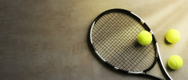 Image of Tennis racket and balls on grey table, flat lay. Banner design with space for text