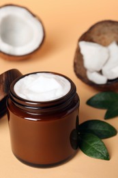 Photo of Jar of coconut face cream on light orange background