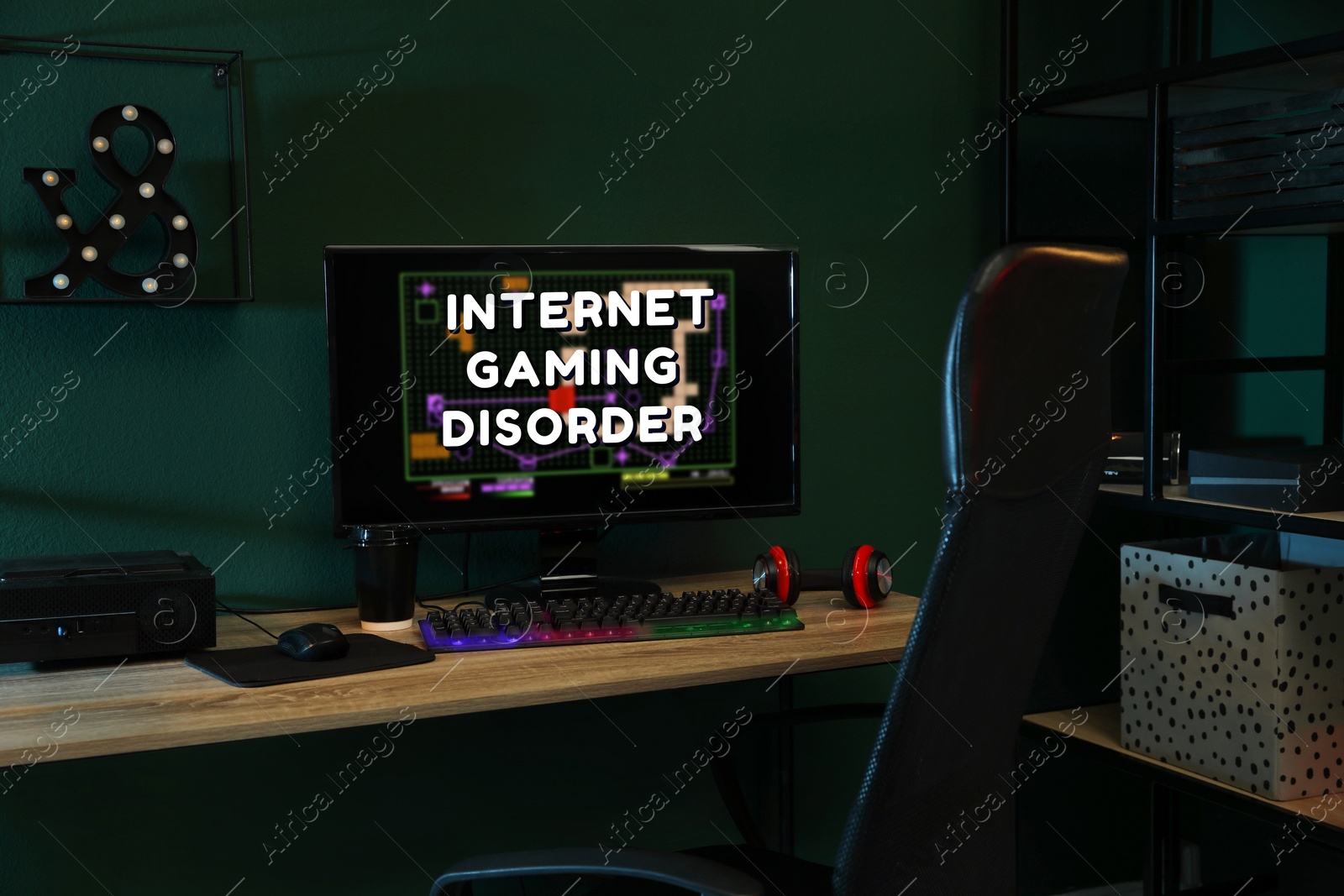 Image of Internet gaming disorder. Modern computer and RGB keyboard on wooden table in dark room