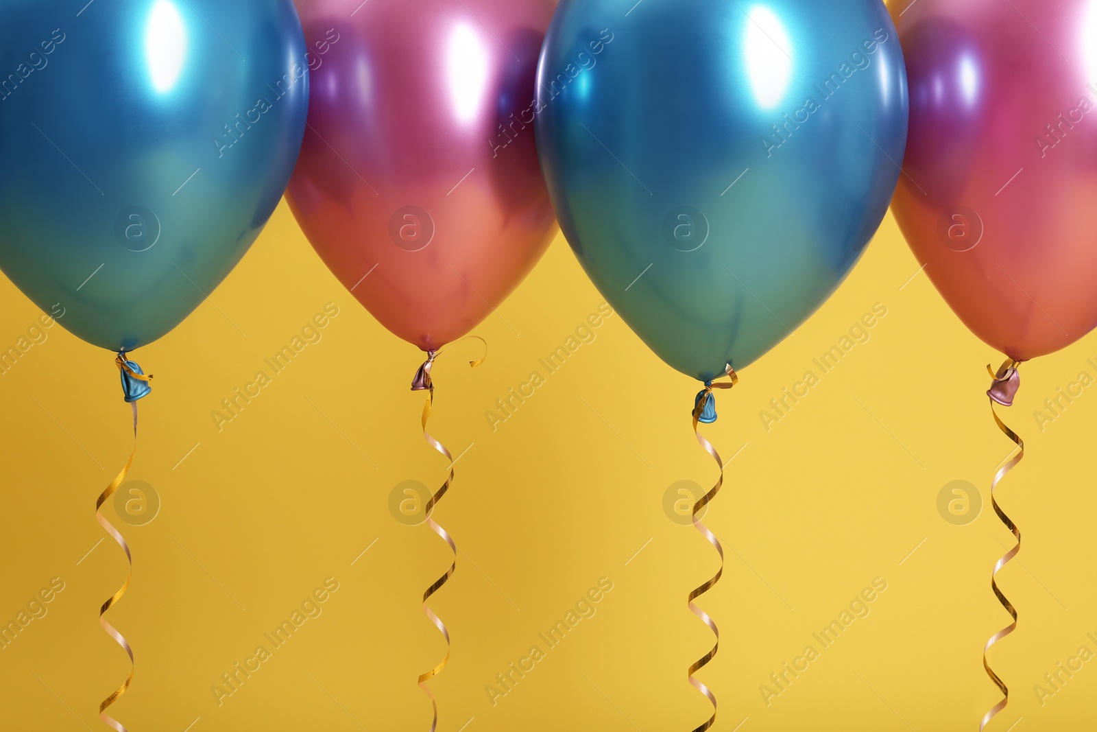 Photo of Bright balloons with ribbons on color background