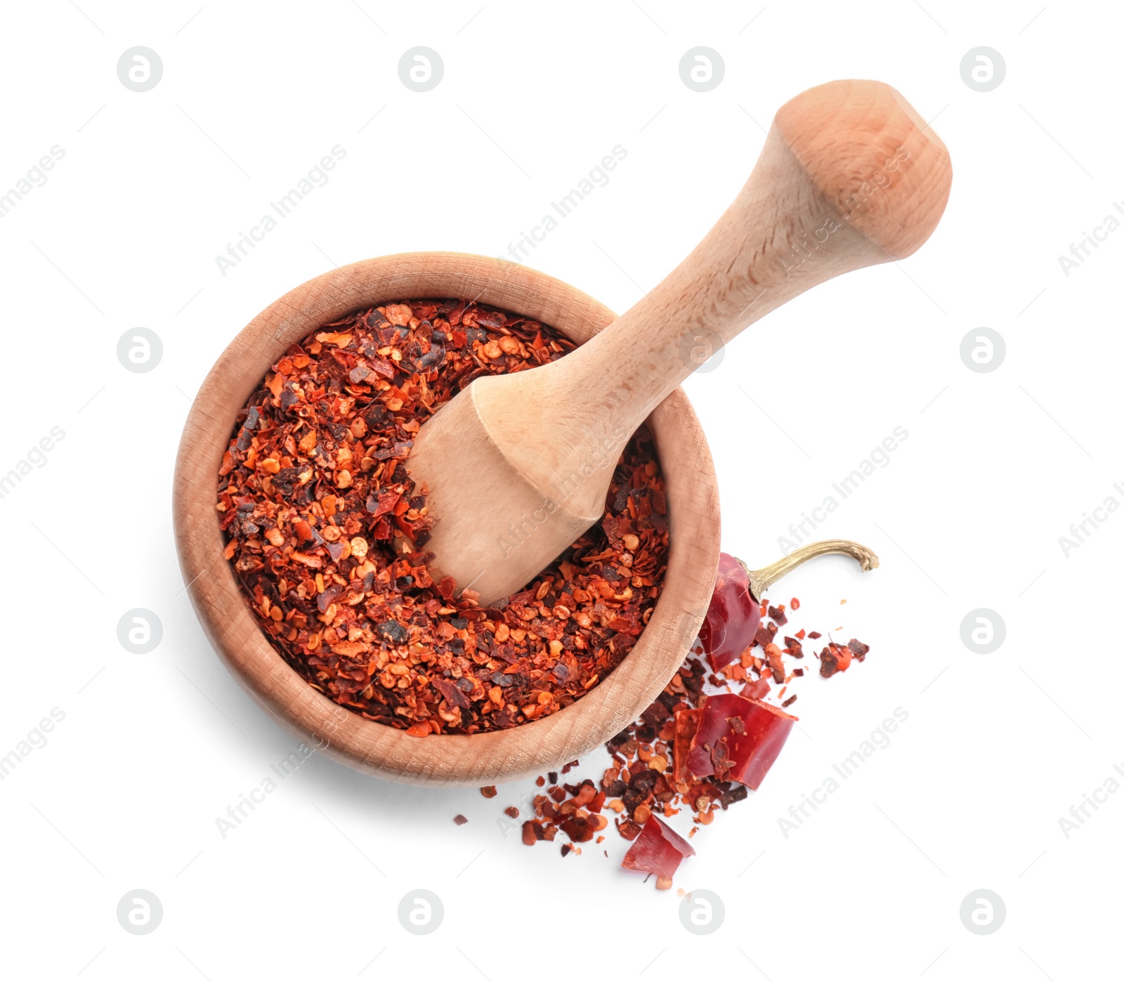 Photo of Wooden mortar with chili pepper flakes on white background, top view