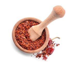 Photo of Wooden mortar with chili pepper flakes on white background, top view