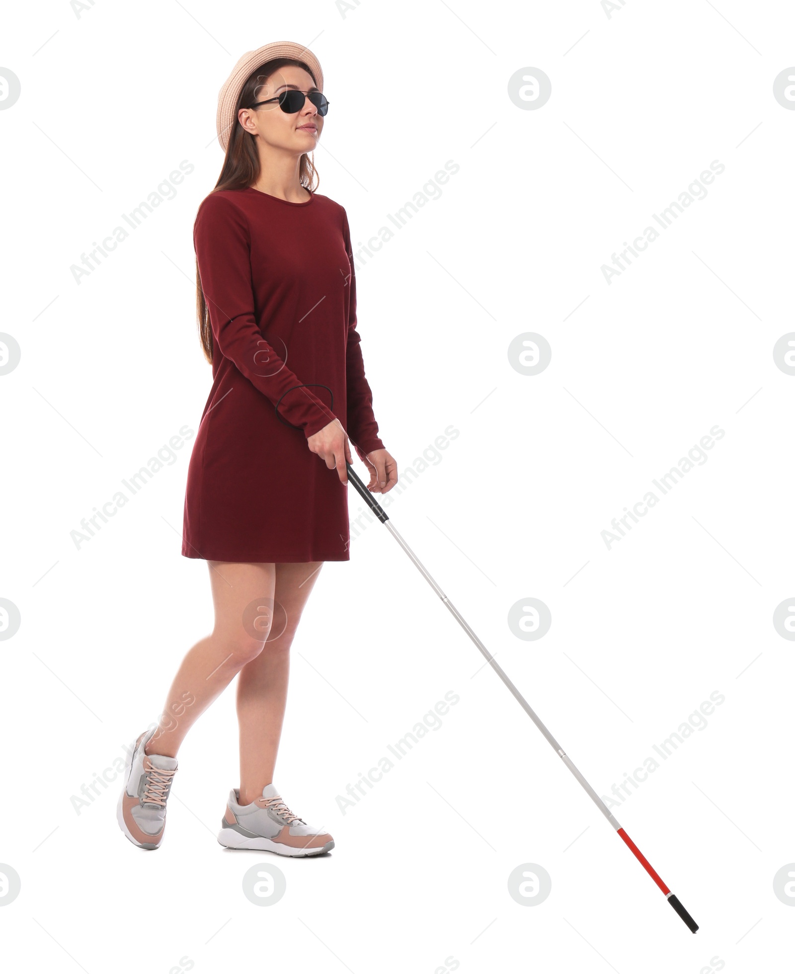 Photo of Young blind person with long cane walking on white background