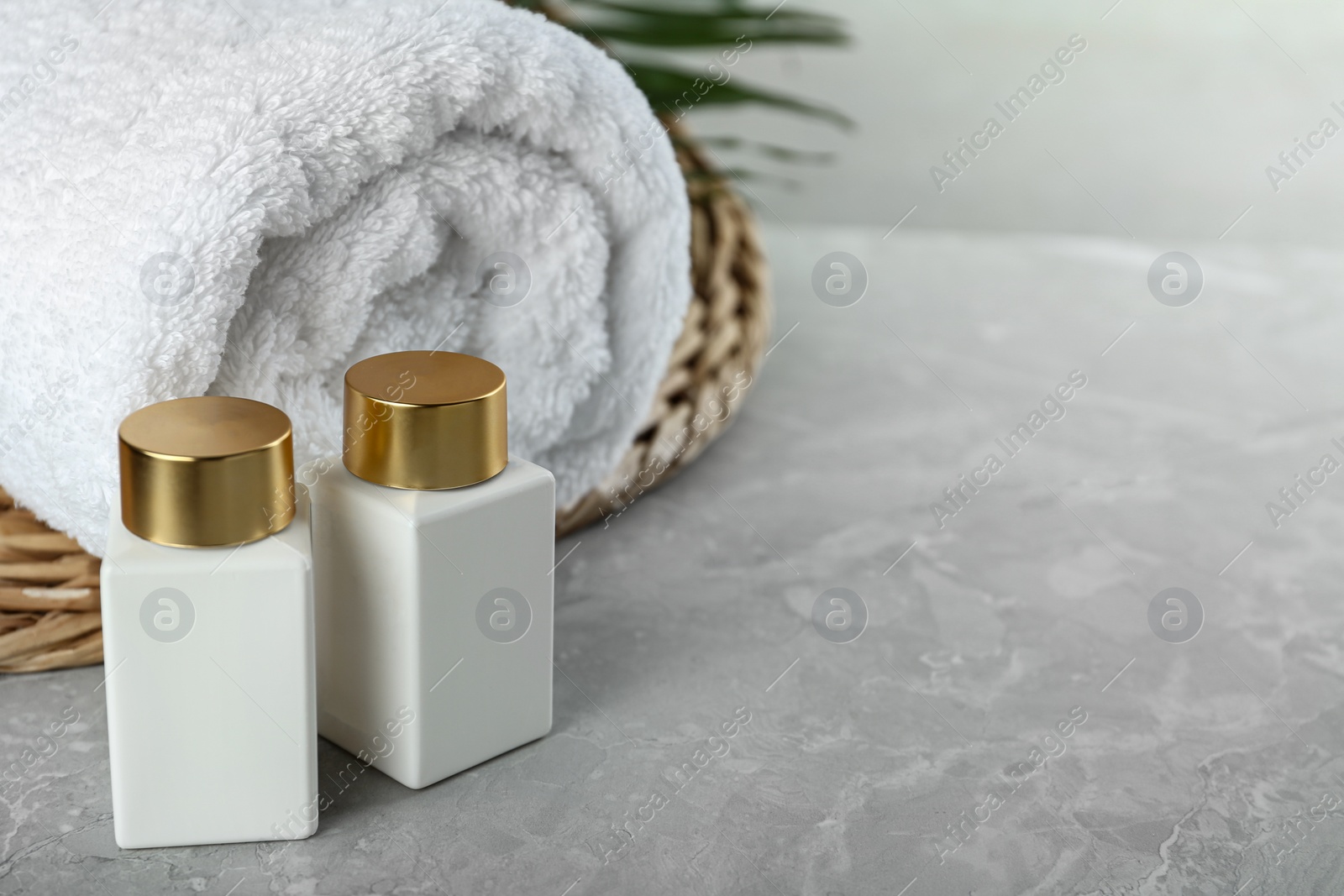 Photo of Composition with cosmetic products on grey stone table, space for text. Spa therapy