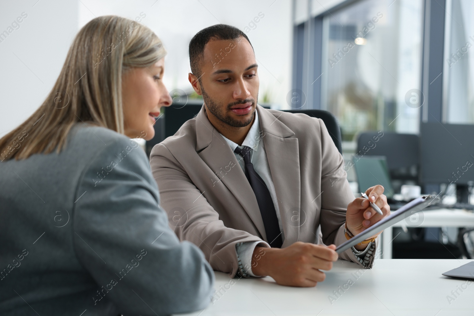 Photo of Lawyers with clipboard working together at table in office