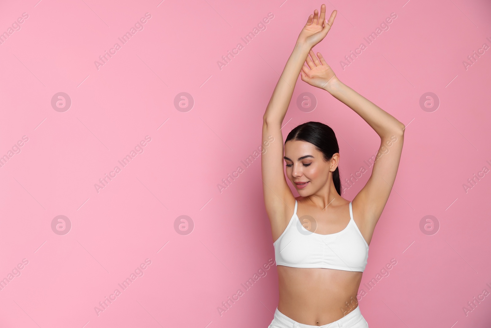 Photo of Young woman showing smooth skin after epilation on pink background, space for text