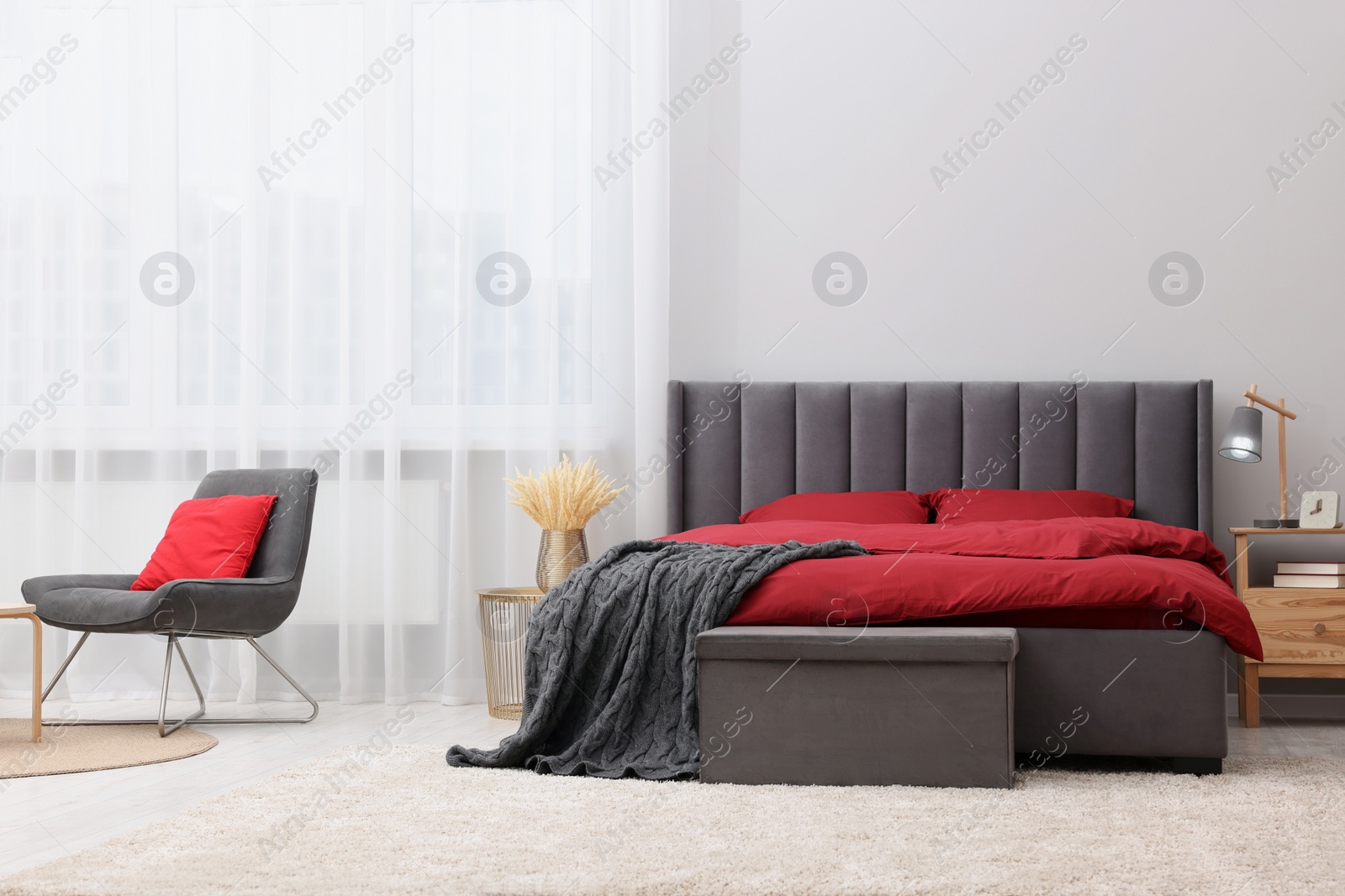 Photo of Stylish bedroom with comfortable bed and armchair. Interior design