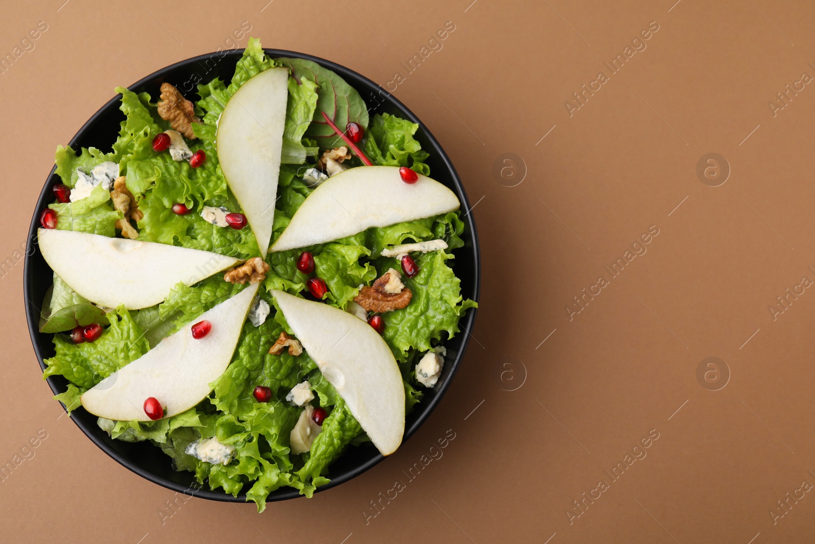 Photo of Delicious pear salad in bowl on beige background, top view. Space for text