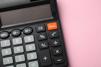 Calculator on pink background, top view. Space for text