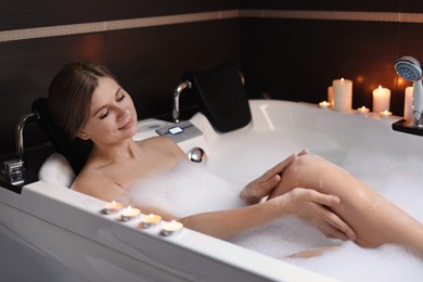 Photo of Beautiful woman taking bubble bath indoors. Romantic atmosphere