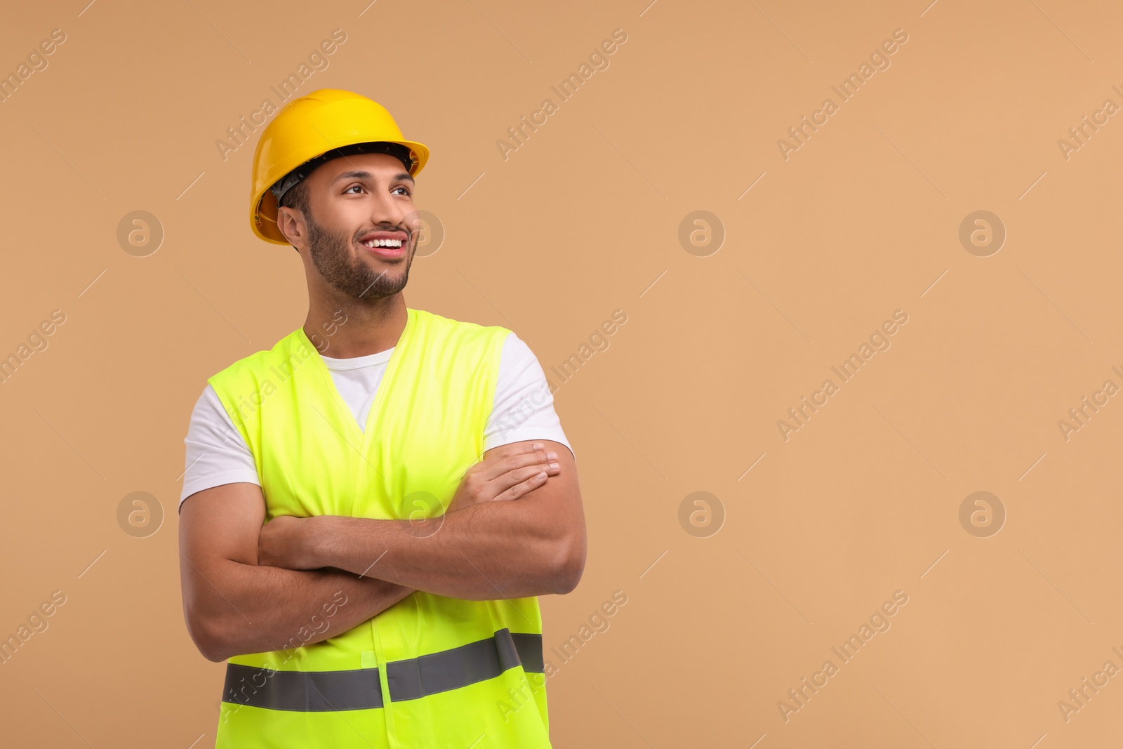 Photo of Engineer in hard hat on beige background, space for text