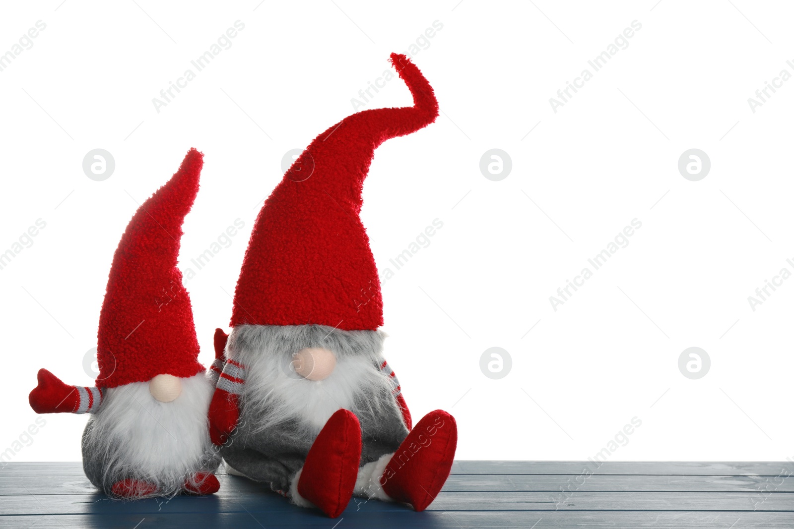 Photo of Funny Christmas gnomes on blue wooden table against white background. Space for text
