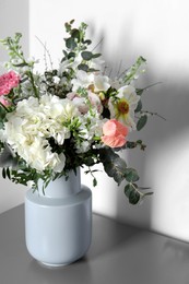 Photo of Bouquet with beautiful flowers on light gray table indoors