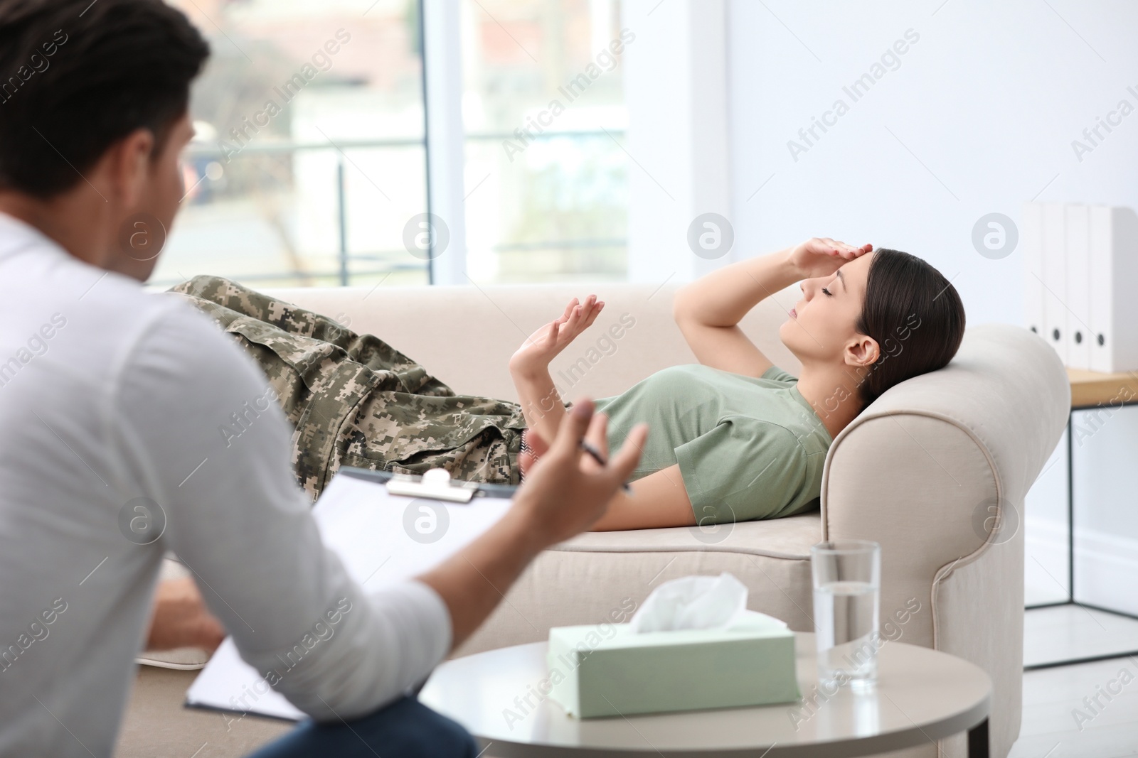 Photo of Psychotherapist working with female military officer in office