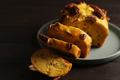 Photo of Delicious pumpkin bread with pecan nuts on wooden table, closeup