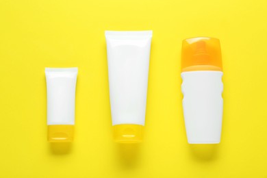 Suntan products on yellow background, flat lay