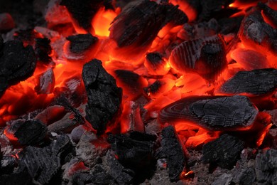 Pieces of hot smoldering coal as background, closeup