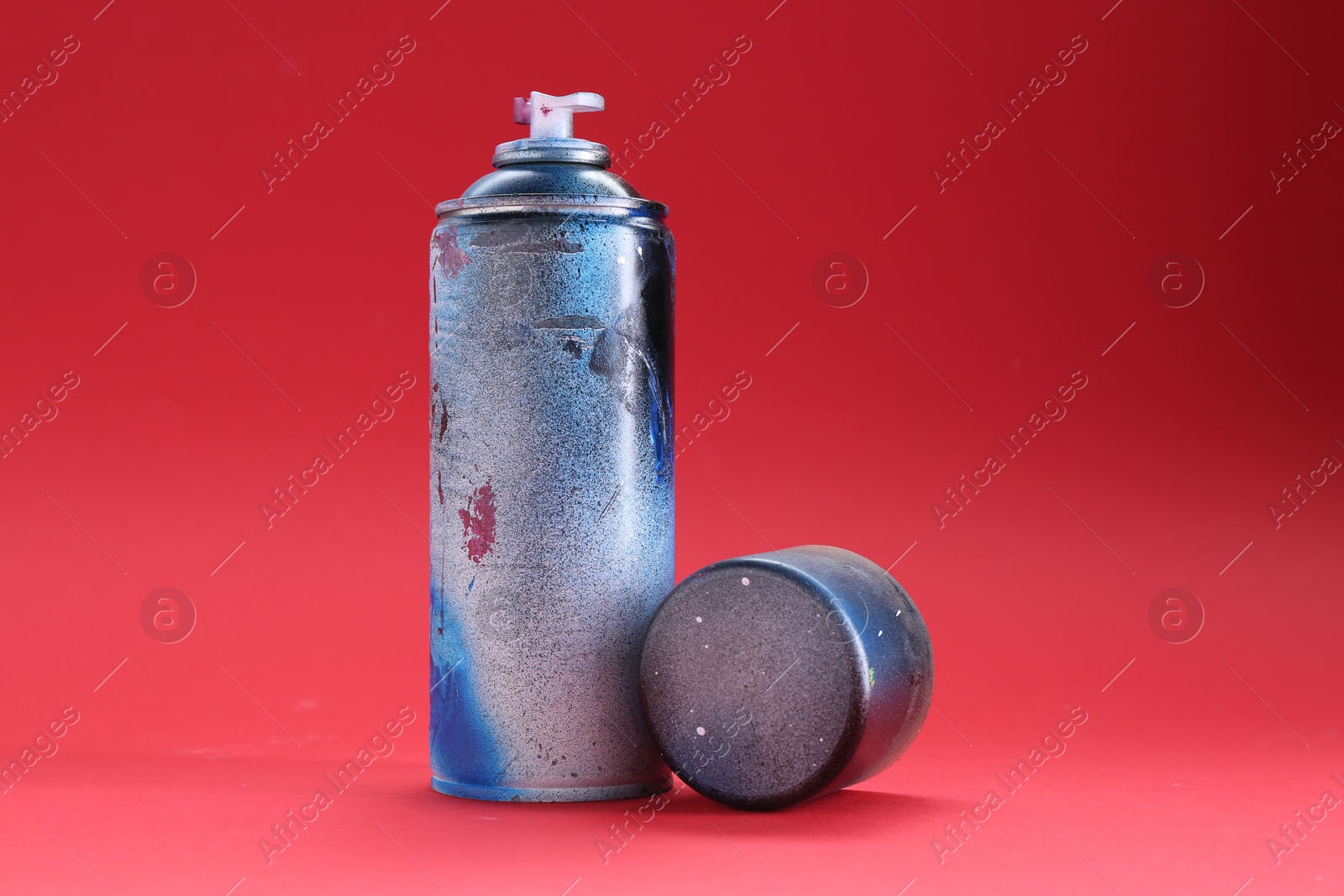 Photo of One can of bright spray paint with cap on red background