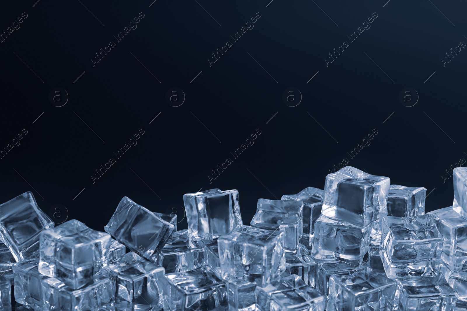 Photo of Crystal clear ice cubes on black background. Space for text