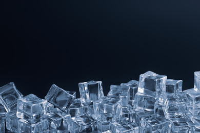 Photo of Crystal clear ice cubes on black background. Space for text