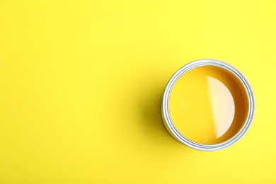 Photo of Paint can on yellow background, top view. Space for text