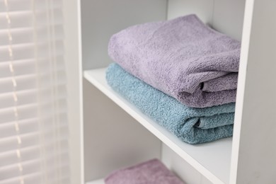 Stacked fesh towels on shelf indoors. Space for text