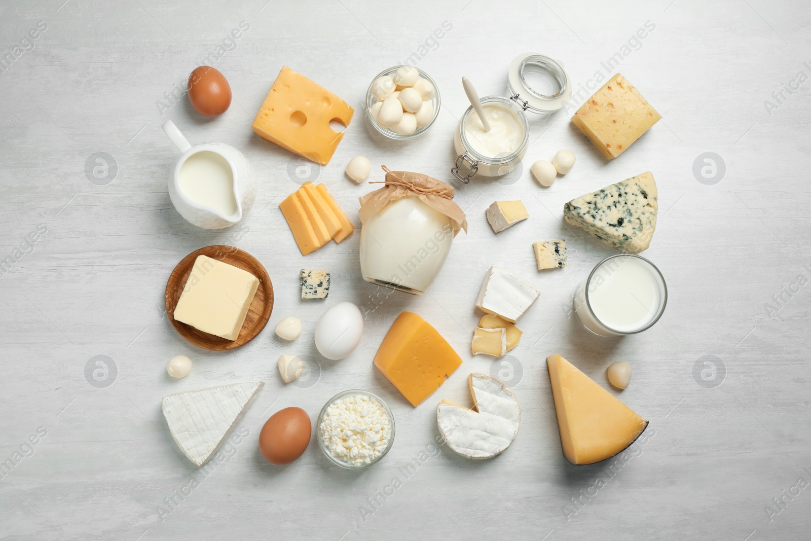 Photo of Different delicious dairy products on white table, flat lay