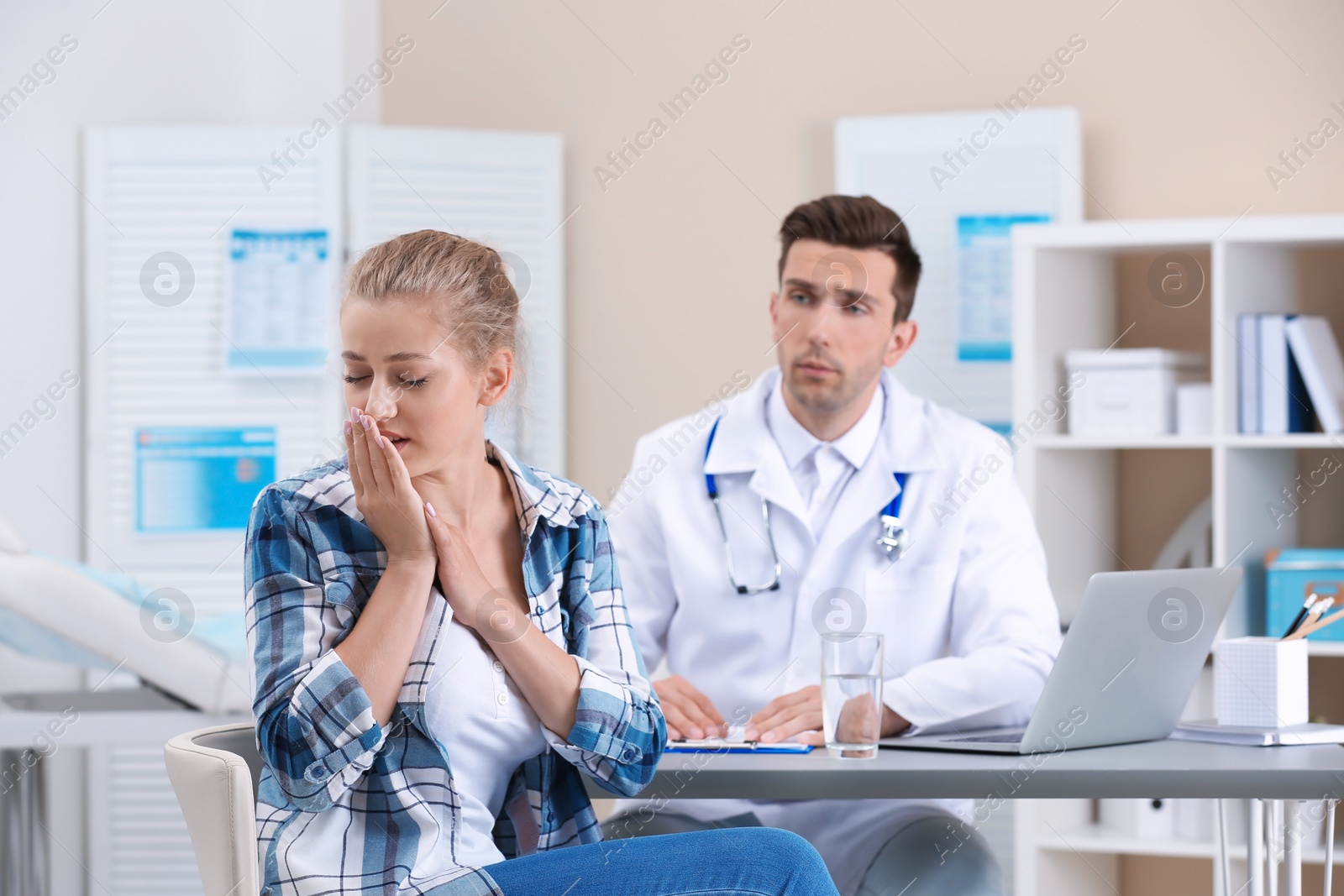 Photo of Coughing young woman visiting doctor at clinic