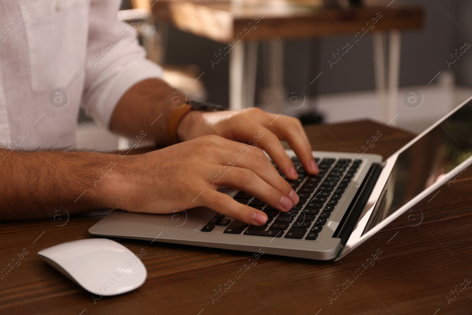 Photo of Freelancer working on laptop at table indoors, closeup