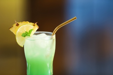 Photo of Fresh alcoholic cocktail with pineapple and lemon on blurred background, closeup. Space for text