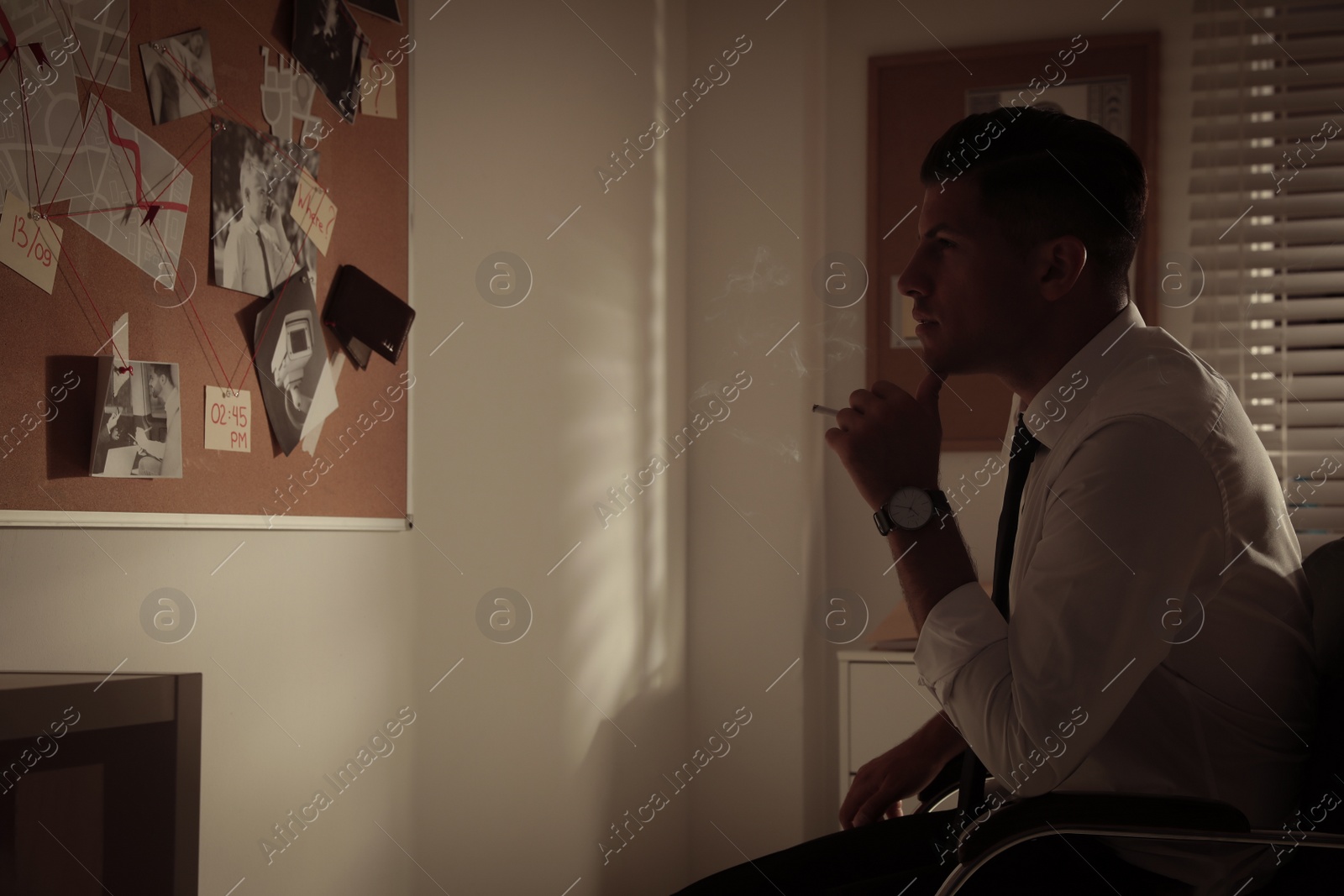 Photo of Detective looking at evidence board in office