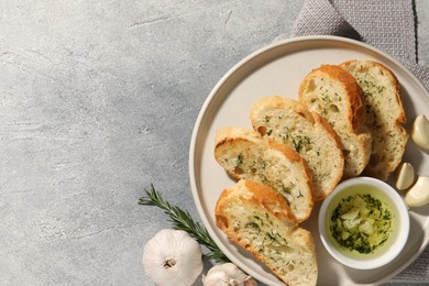 Tasty baguette with garlic and dill served on grey textured table, top view. Space for text