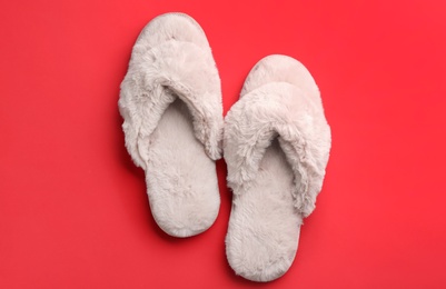 Pair of stylish soft slippers on red background, flat lay