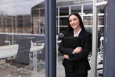 Photo of Female real estate agent with leather portfolio in office