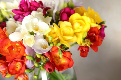 Photo of Beautiful spring freesia flowers in vase, closeup