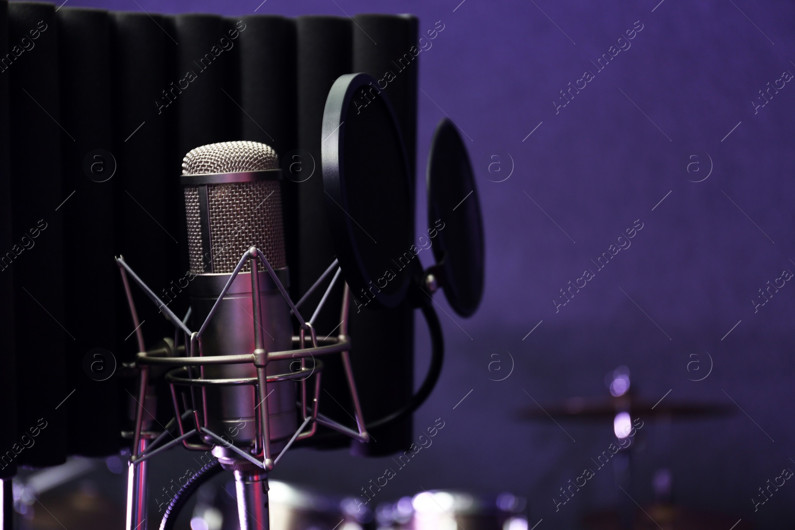 Photo of Condenser microphone in modern recording studio. Space for text