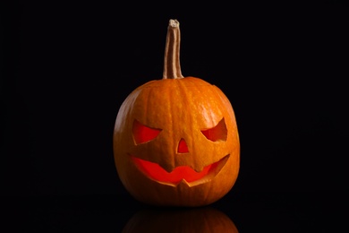 Photo of Pumpkin head on black background. Jack lantern - traditional Halloween decor