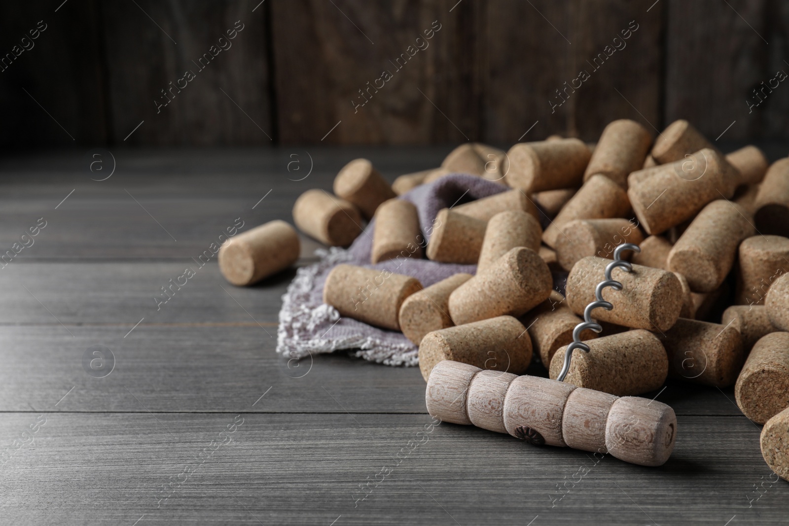 Photo of Corkscrew and wine bottle stoppers on wooden table