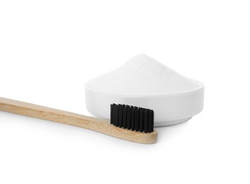 Bamboo toothbrush and bowl with baking soda on white background