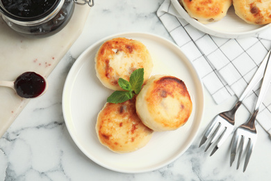 Delicious cottage cheese pancakes on white marble table, flat lay