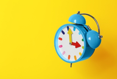 Photo of Alarm clock on yellow background. Space for text