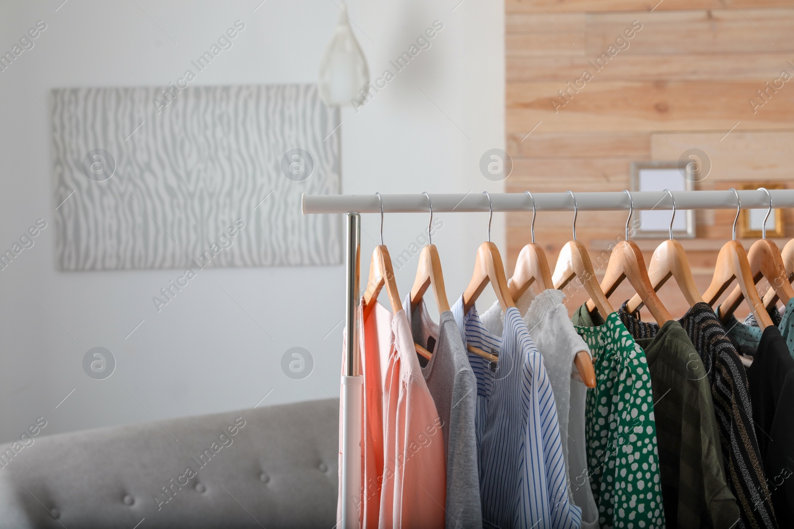 Photo of Wardrobe rack with stylish female clothes indoors, space for text