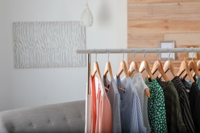 Photo of Wardrobe rack with stylish female clothes indoors, space for text
