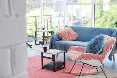 Photo of Elegant living room interior with rocking chair and cozy sofa