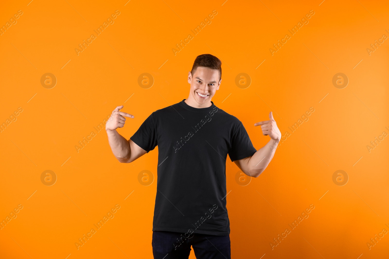 Photo of Young man in black t-shirt on color background. Mockup for design