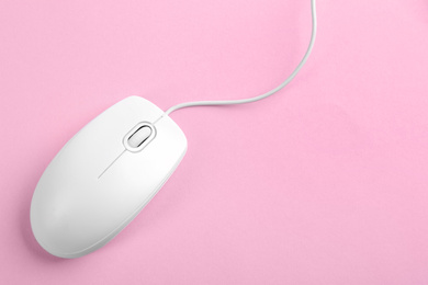 Modern wired optical mouse on pink background, top view