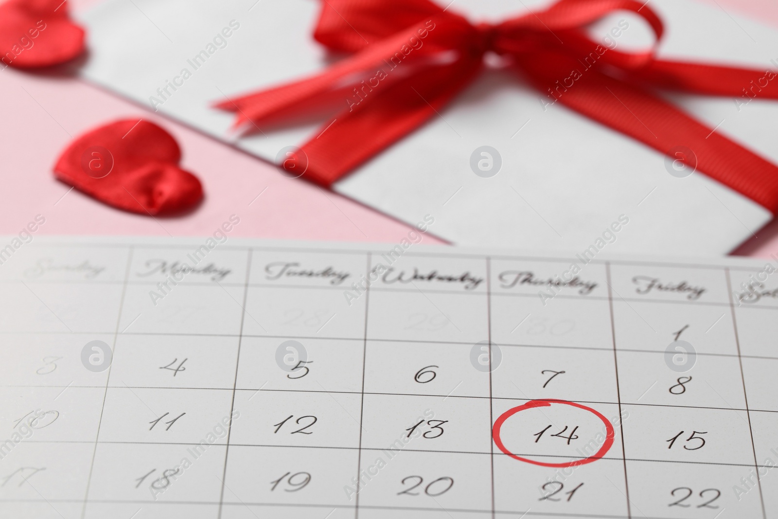 Photo of Calendar with marked Valentine's Day on pink background, closeup