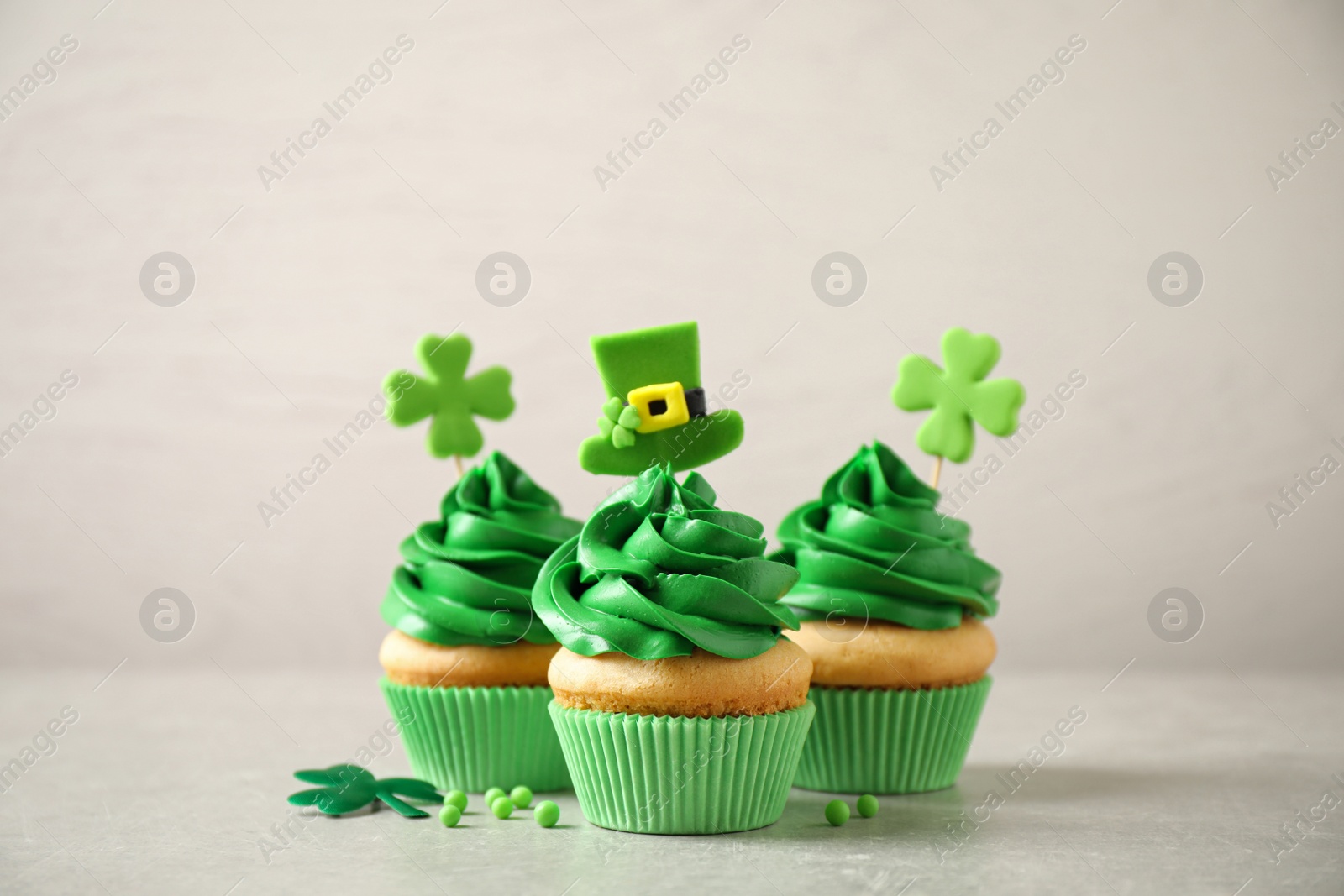 Photo of Delicious decorated cupcakes on light table. St. Patrick's Day celebration