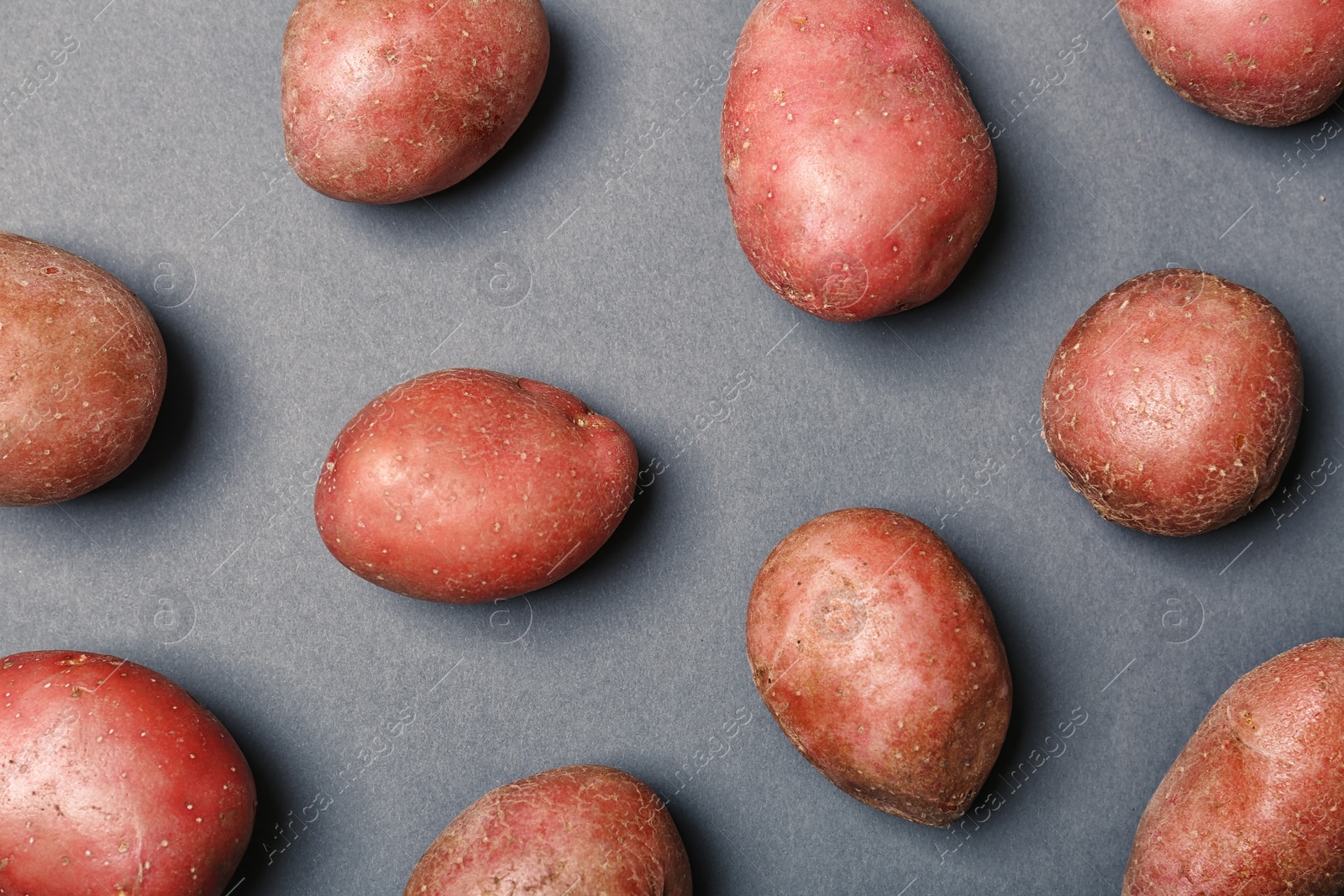 Photo of Flat lay composition with fresh organic potatoes on grey background